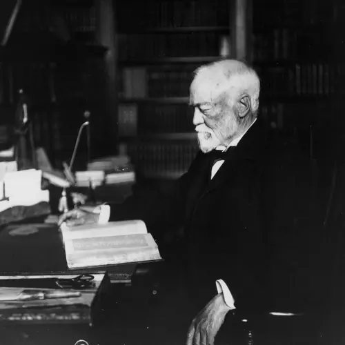 Andrew Carnegie seated at a desk with a book, circa 1913 1913